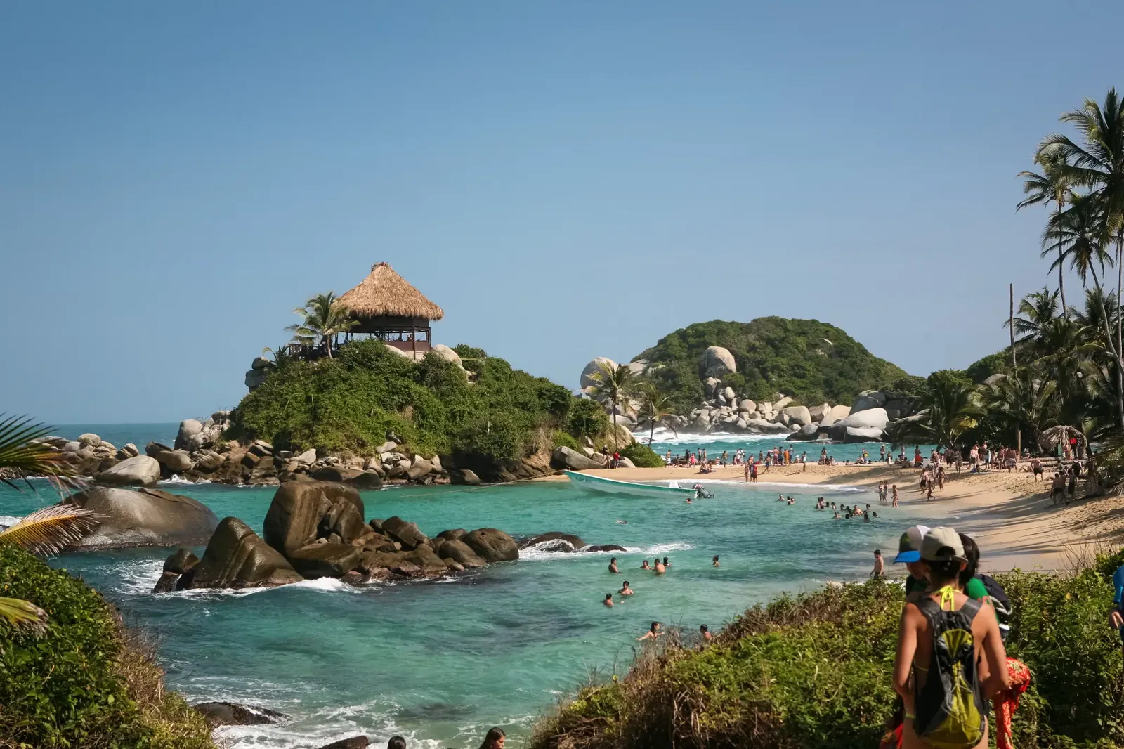 Bahía del Caribe colombiano con palmeras y montaña al fondo